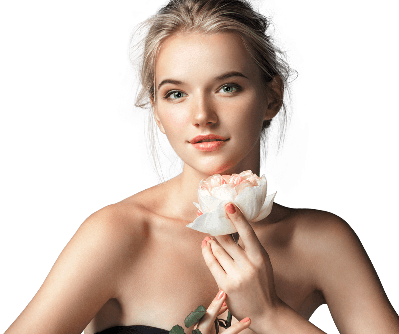 A woman holding a flower up to her face and smiling